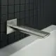 Wandauslauf von Ideal Standard, rechteckige Rosette, montiert an einer dunklen Fliese, mit einer schmalen, flachen Auslaufkante über einer weißen Badewanne.